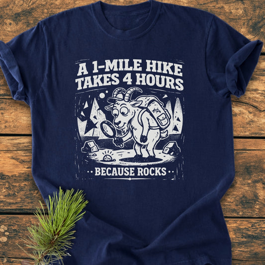 Because Rocks - Vintage Wash Tee: A navy-blue T-shirt featuring a cartoon goat with a backpack examining a rock with a magnifying glass, paired with the humorous slogan about hiking and rocks.