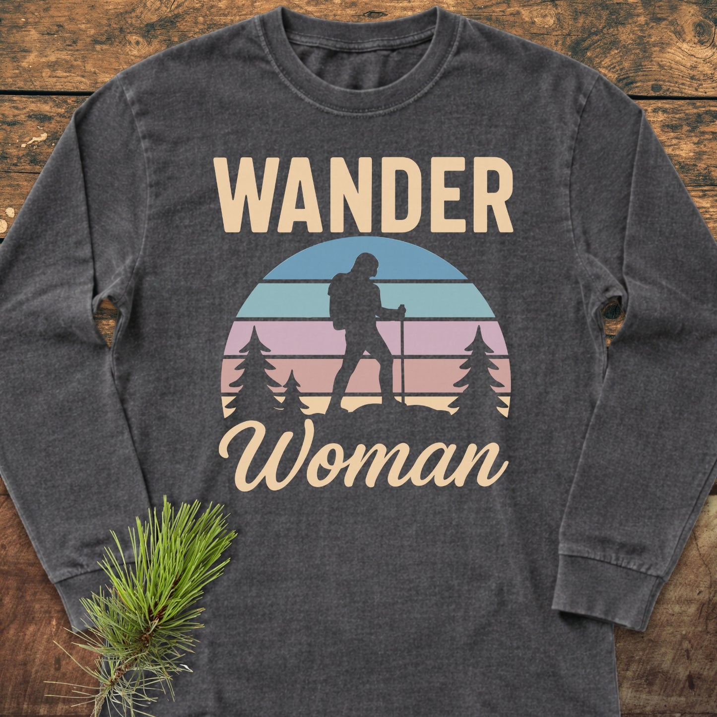 Wander Woman Retro Long-Sleeve Tee featuring a pastel sunset graphic with a hiker silhouette, crafted from 100% ring-spun cotton for a relaxed fit, styled with a pine sprig.