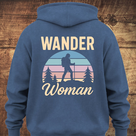 Back of the Wander Woman Retro Hoodie, featuring a circular sunset graphic with a silhouetted hiker and pine trees, framed by WANDER above and Woman below, on a soft, unisex garment-dyed hoodie.