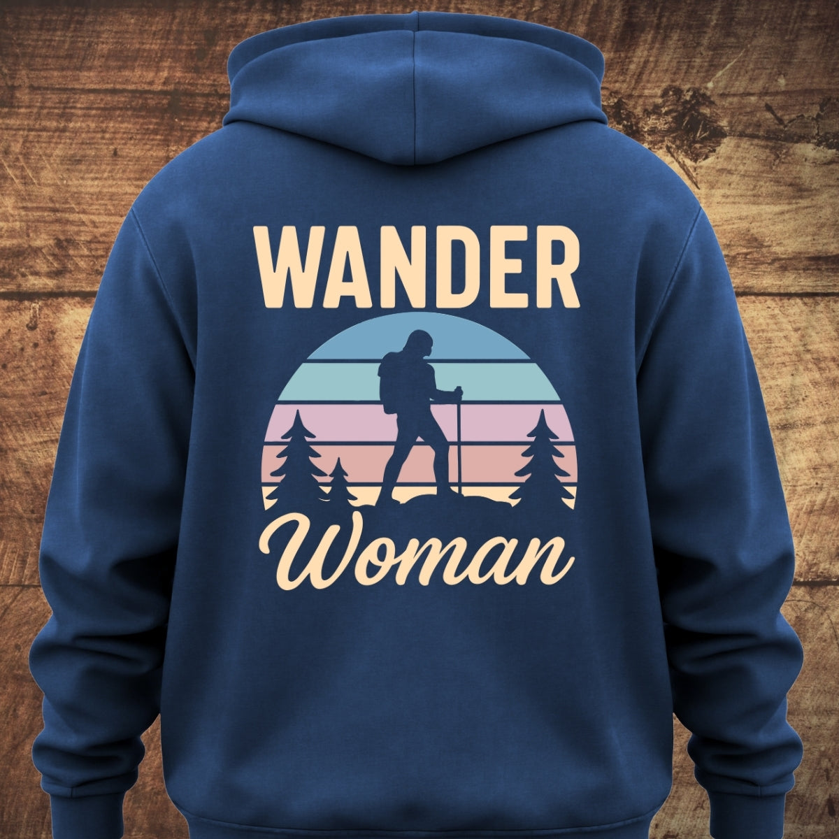 Back of the Wander Woman Retro Hoodie BACKPRINT featuring a pastel-striped semicircle with a woman hiking silhouette, WANDER in bold above, and Woman in script below.