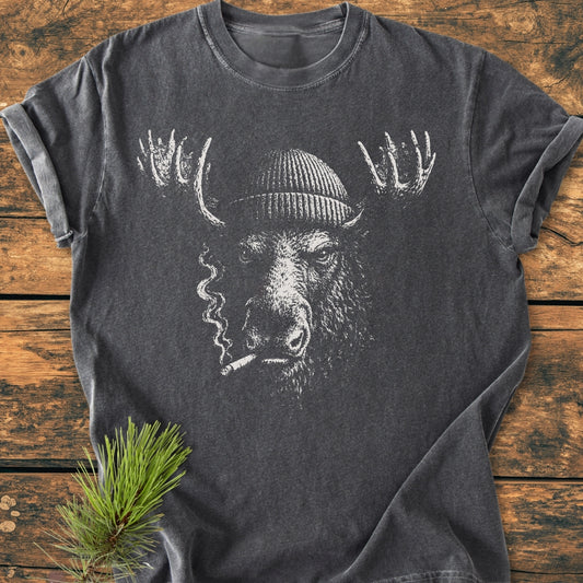 Slow Burn Moose - Vintage Wash Tee with a sketch-style moose graphic in a beanie, cigarette in mouth, on a wooden surface, complemented by a pine sprig. Made from soft, durable, ring-spun cotton.