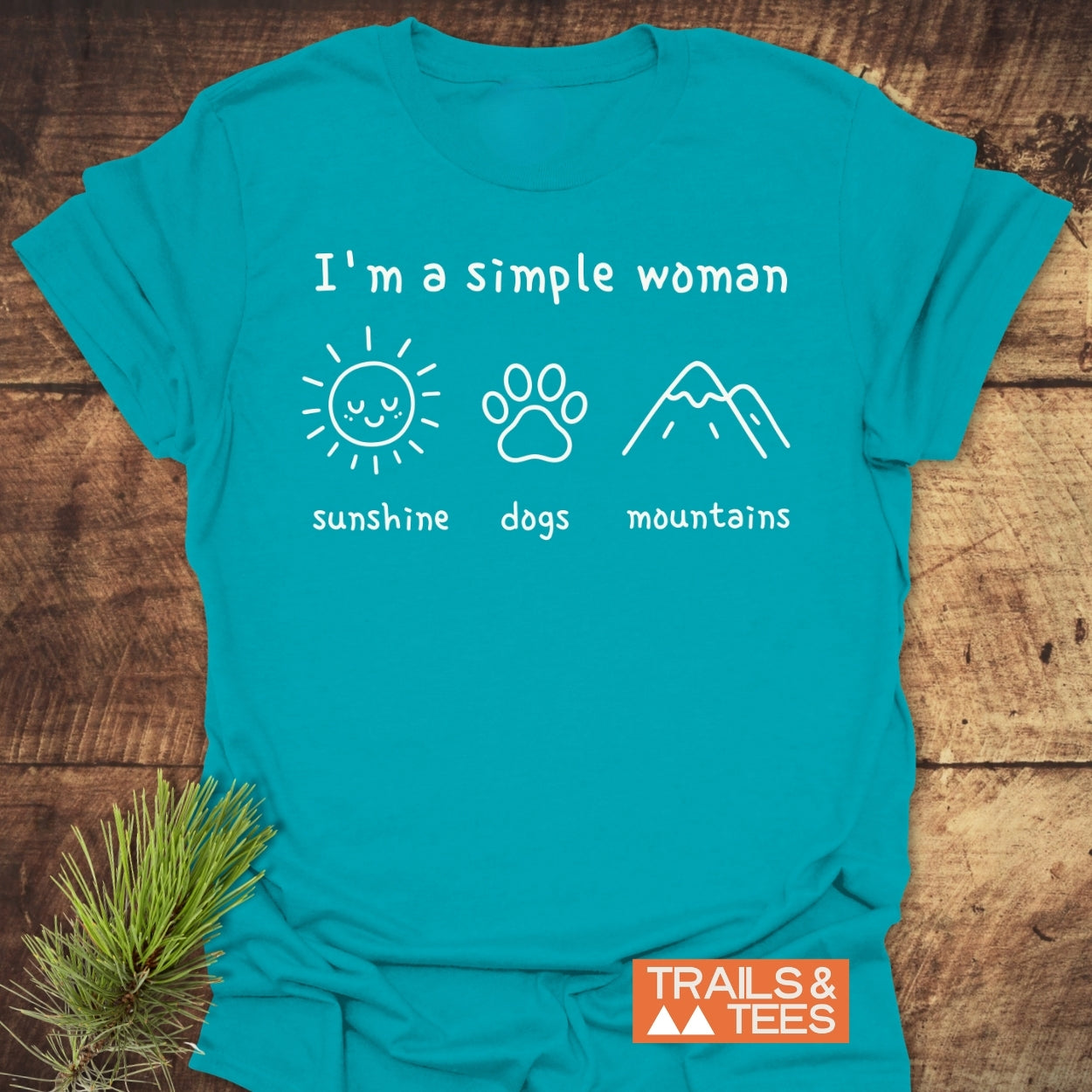 I'm A Simple Woman - Sunshine, Dogs, Mountains T-Shirt features white icons of a sun, dog paw, and mountains on a teal T-shirt, highlighting outdoor love with durable prints and comfort.