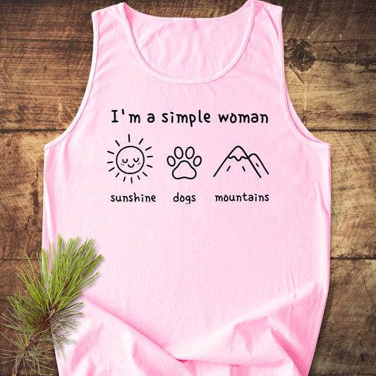 I'm A Simple Woman - Sunshine, Dogs, Mountains Tank Top features black line art and text on a light pink tank, laid flat with a pine branch accent, highlighting comfort and sustainability.