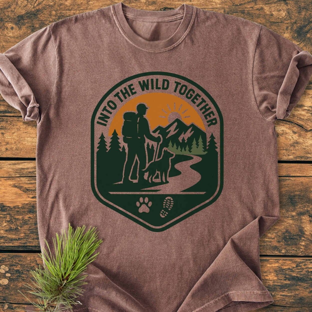 Into The Wild Together - Vintage Wash Tee features a badge-style graphic with a hiker, dog, trail, and mountain. Celebrates nature adventures, made from soft, durable 100% ring-spun cotton for comfort.