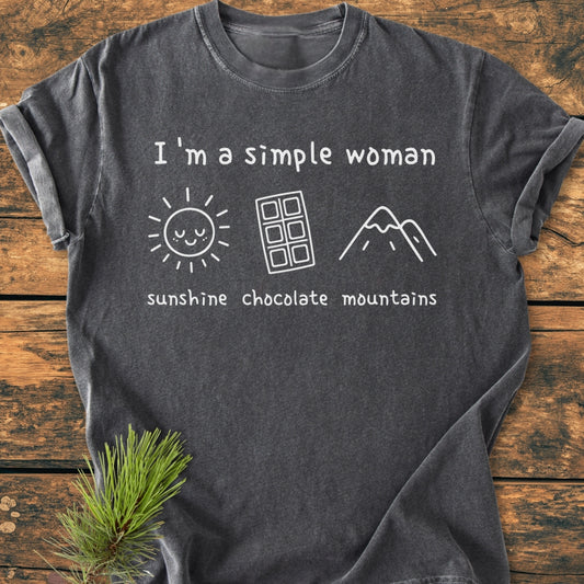 I'm A Simple Woman. Sunshine Chocolate Mountains - Vintage Wash Tee, featuring a charcoal-gray color, relaxed fit, and white slogan with icons of a sun, chocolate bar, and mountains, laid flat.
