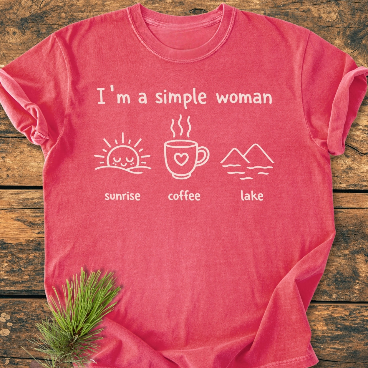 I'm A Simple Woman - Sunrise Coffee Lake - Vintage Wash Tee, displayed flat on wood, features a white graphic with sunrise, coffee, and lake icons, emphasizing comfort and durability with a relaxed fit.