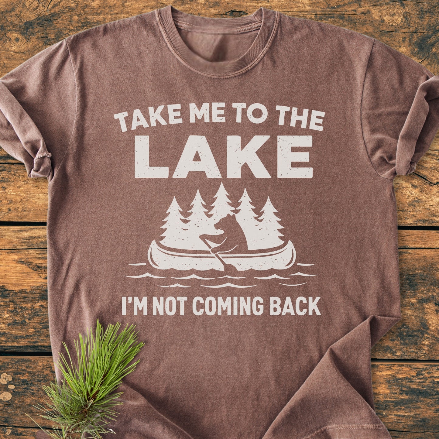 Take Me To The Lake - Vintage Wash Tee features white screen-printed slogan and canoe graphic, styled with a pine sprig. Made of soft, garment-dyed cotton with a relaxed fit.