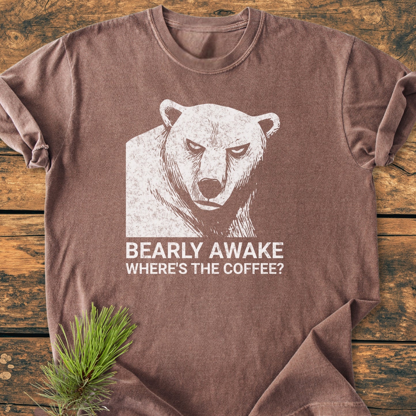 Bearly Awake - Vintage Wash Tee featuring a grumpy bear and “WHERE’S THE COFFEE?” caption, laid on rustic wood. Cozy, relaxed fit made from 100% ring-spun cotton, perfect for daily wear.