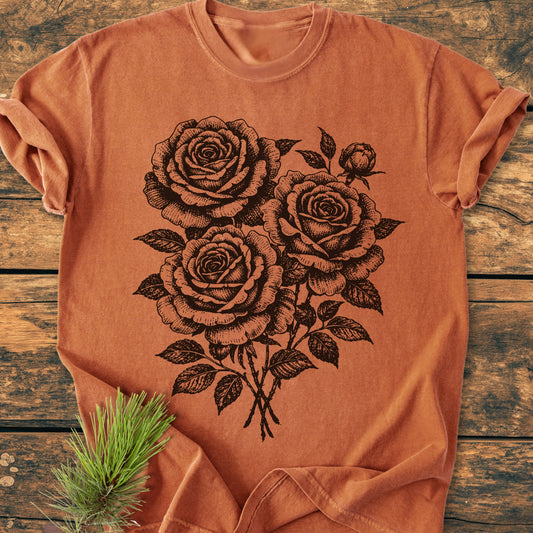Rose Bouquet - Vintage Heavyweight Tee featuring a black hand-drawn rose bouquet print, laid on weathered wood with a pine branch. Crafted from soft, durable ring-spun cotton, offering a relaxed fit.
