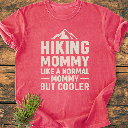 The Hiking Mommy - Vintage Heavyweight Tee features an off-white slogan with a mountain silhouette, styled with a pine sprig, showcasing its relaxed fit and soft-washed, durable fabric.
