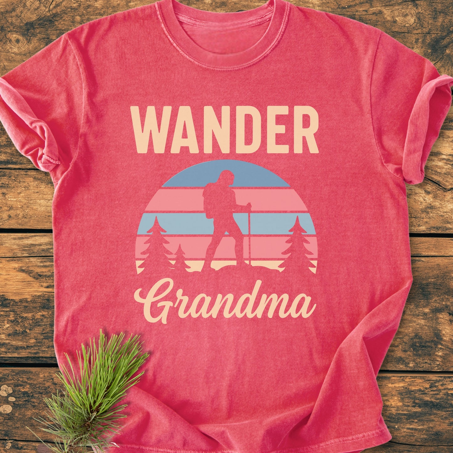 Wander Grandma - Vintage Heavyweight Tee showcases a stylized outdoor scene with pine trees and a hiker, printed on a folded, vintage-washed T-shirt, emphasizing comfort and durability.