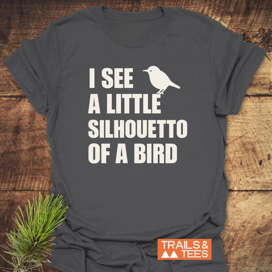 Silhouetto Of A Bird Funny Softstyle T-Shirt in charcoal-gray, featuring cream-colored bird silhouette and bold text. Displays TRAILS & TEES. logo, emphasizing lightweight comfort and modern semi-fitted cut.