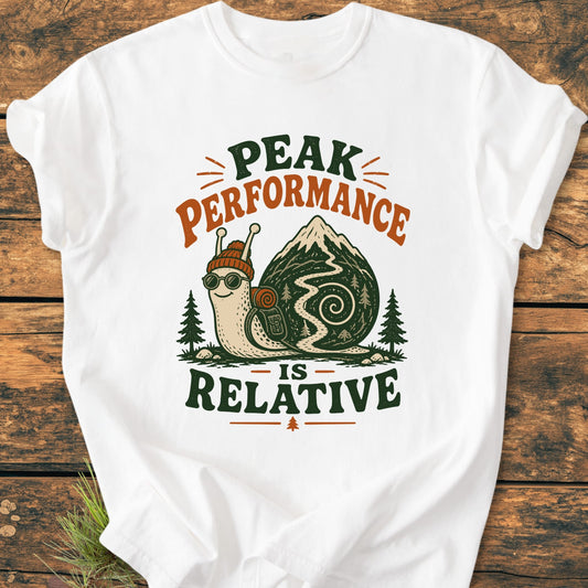 Peak Performance Is Relative - Vintage Wash Tee: White T-shirt with a cartoon snail in hiking gear on a mountain trail, featuring the slogan above and below, ideal for leisurely adventurers.