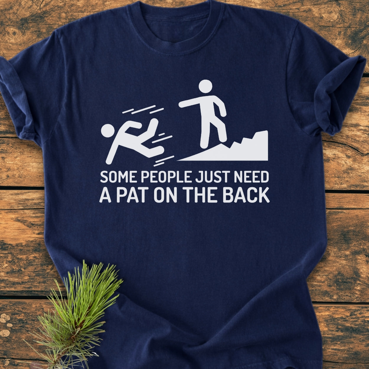 Some People Just Need A Pat On The Back - Vintage Wash Tee features a stick-figure graphic and cheeky caption, laid flat on wood. Ideal for hikers valuing comfort and humor.