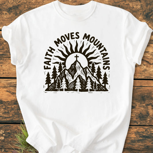 1409 Faith Moves Mountains T-shirt features a mountain scene with pine trees, a sun, and a cross on the summit, complemented by the slogan. Crafted from soft, durable, 100% ring-spun cotton.