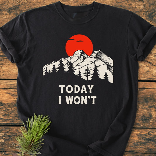 Black long-sleeve tee 1423 Today I Won't with snow-capped mountains, pine trees, and red sun graphic, laid on wooden surface, embodying a vintage, lived-in look for everyday adventures.