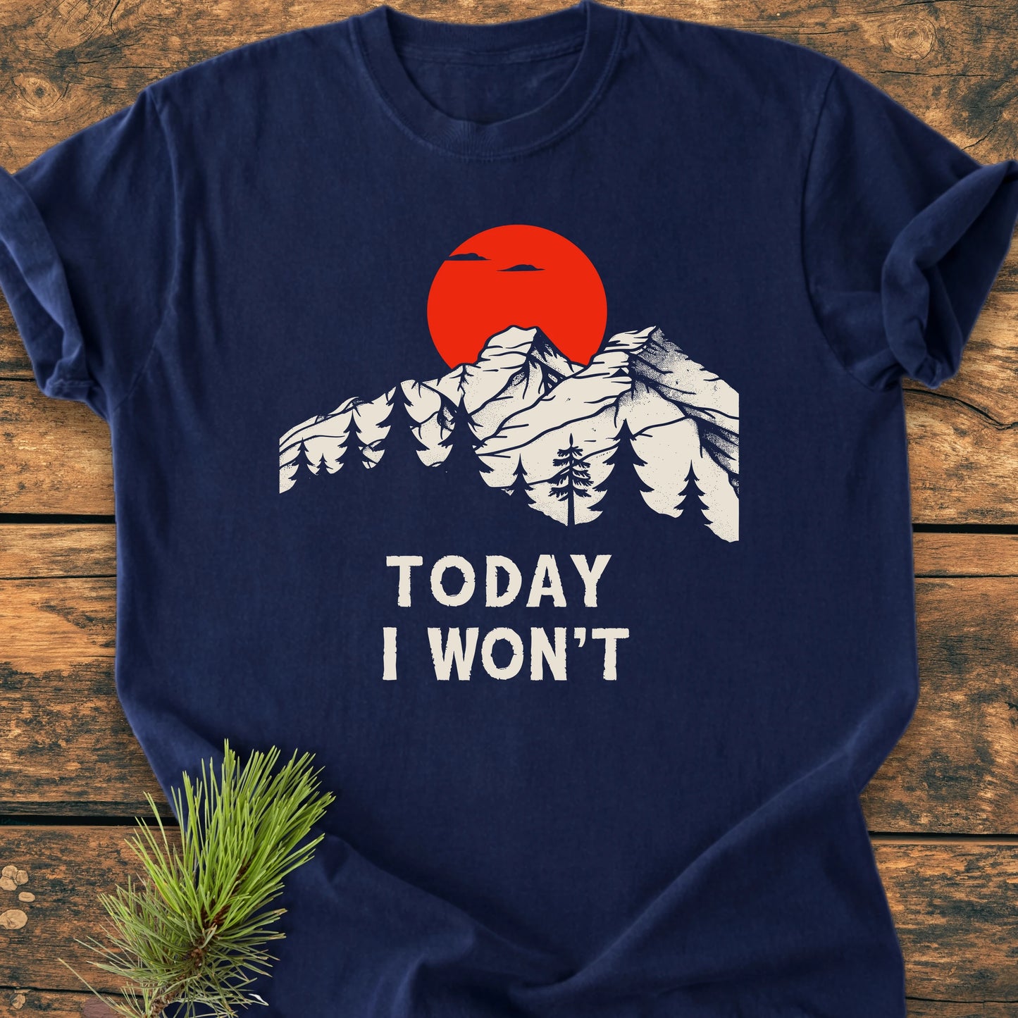 Navy-blue T-shirt flat on wood, featuring a white mountain and pine silhouette with a red sun, captioned TODAY I WON'T, reflecting the 1423 Today I Won't vintage style.