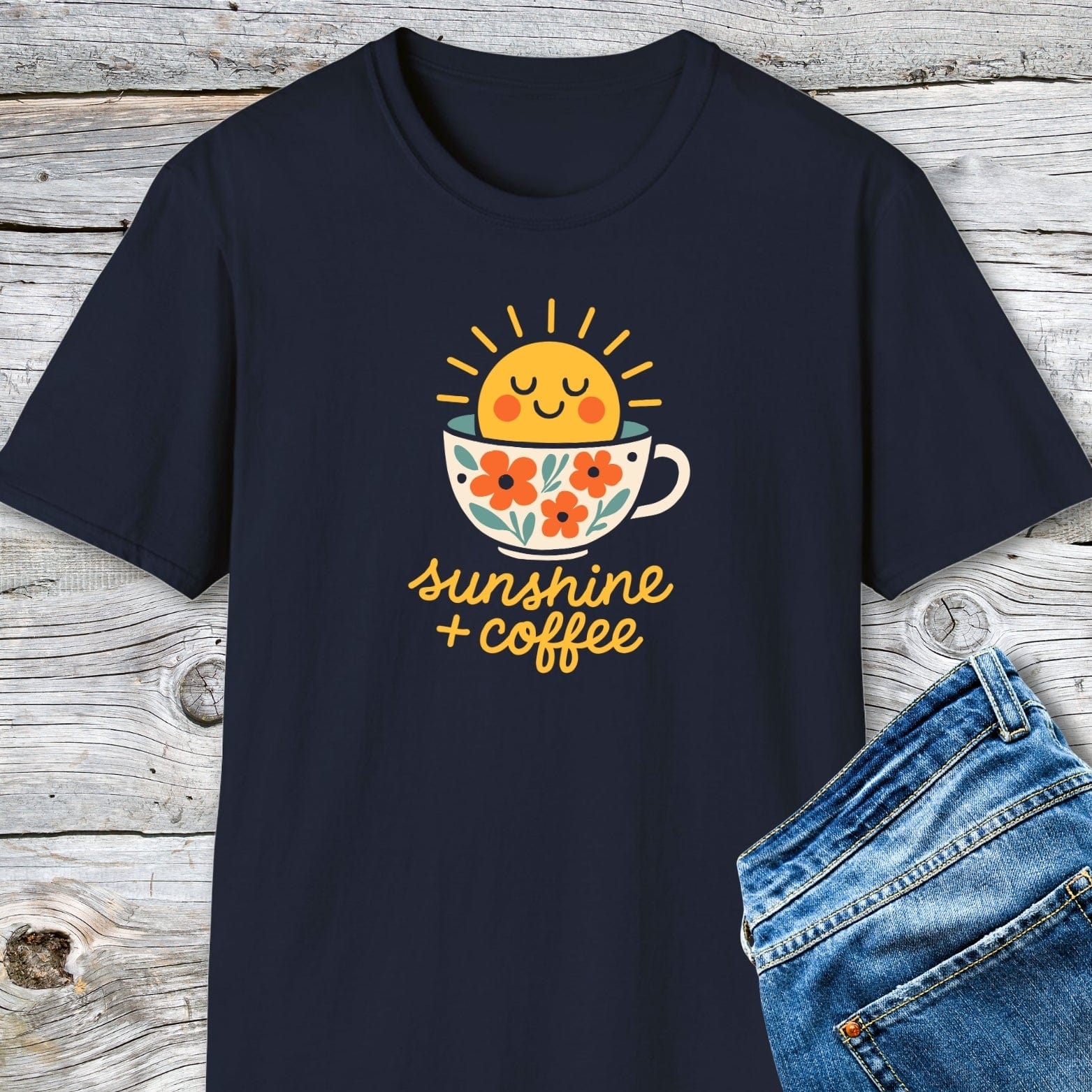 Sunshine And Coffee T-Shirt with a smiling sun graphic on a coffee cup, paired with blue jeans, highlighting its soft, lightweight cotton for everyday comfort.