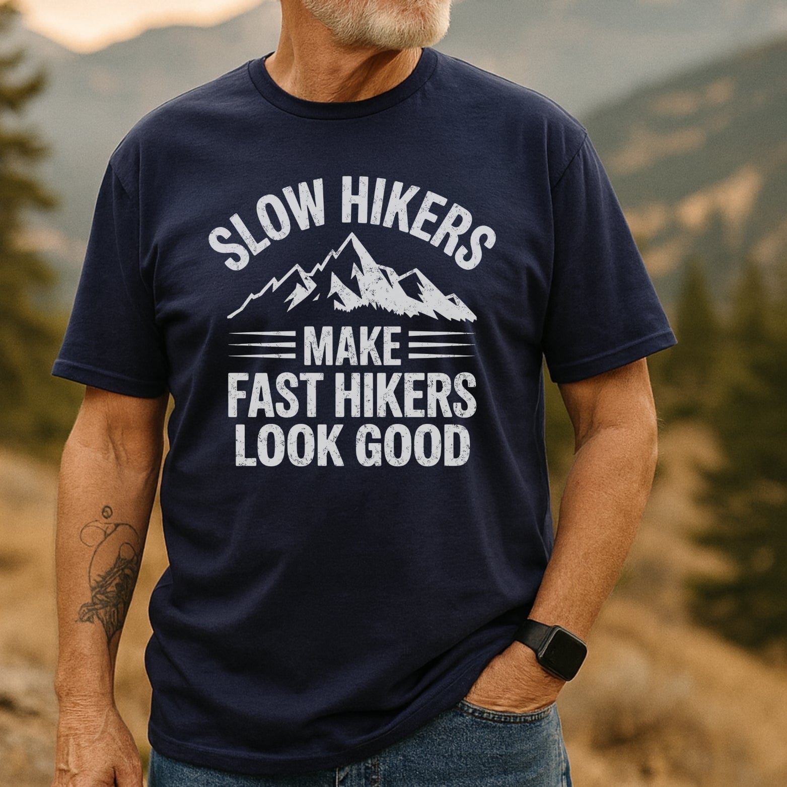 Middle-aged man outdoors in navy Slow Hikers T-Shirt, showcasing distressed lettering and mountain graphic, embodying comfort and adventure-ready design.