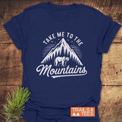 Take Me To The Mountains T-Shirt featuring a mountain and bear graphic, showcasing outdoorsy appeal. Navy-blue, lightweight cotton for comfort, with durable prints and eco-friendly production.