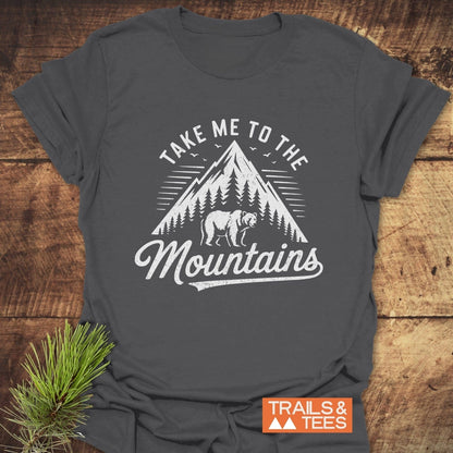 Take Me To The Mountains T-Shirt featuring a mountain and bear print, designed for comfort and adventure in soft, durable cotton.