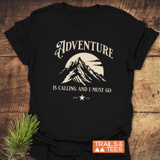 Adventure Is Calling T-Shirt featuring a black and white mountain design, crafted from soft, lightweight cotton for comfort and durability, ideal for outdoor enthusiasts.