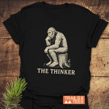 Bigfoot The Thinker T-Shirt featuring a gorilla drawing on a stump, crafted from soft cotton, pre-shrunk, with durable prints for outdoor enthusiasts.