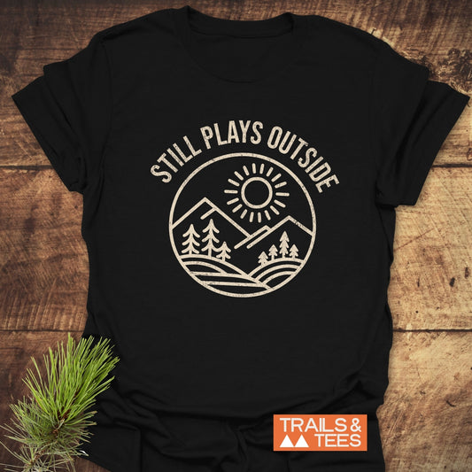 Still Plays Outside T-Shirt featuring white text, crafted from lightweight ring-spun cotton for comfort, designed for outdoor enthusiasts with durable, fade-resistant prints.