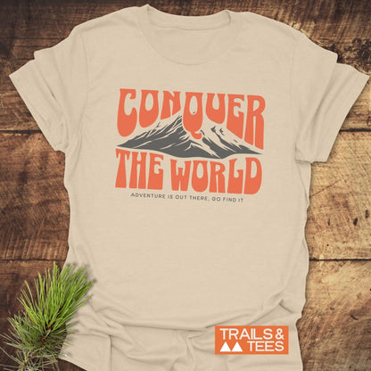 Conquer The World T-Shirt laid flat on a table, featuring a dynamic design ideal for active wear.