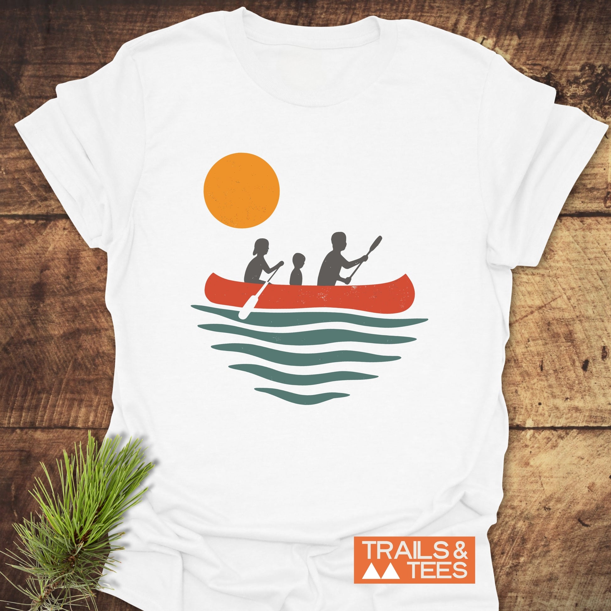 Family Canoe T-Shirt featuring a silhouette of a boy with a paddle and people in a canoe, crafted for outdoor enthusiasts from ring-spun cotton.