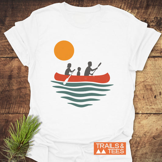 Family Canoe T-Shirt featuring a silhouette of a boy with a paddle and people in a canoe, crafted for outdoor enthusiasts from ring-spun cotton.
