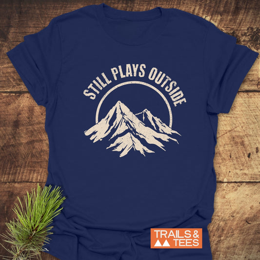 Still Plays Outside T-Shirt featuring durable white text, crafted from soft ring-spun cotton for comfort and adventure-ready durability.