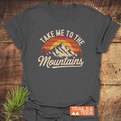 Take Me To The Mountains T-Shirt featuring a graphic design, displayed on a table, highlighting its active wear appeal.