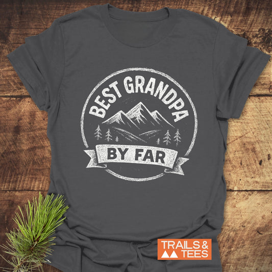 Best Grandpa By Far T-Shirt with mountain design, crafted from soft ring-spun cotton, featuring durable prints for lasting wear, laid on rustic wood surface.