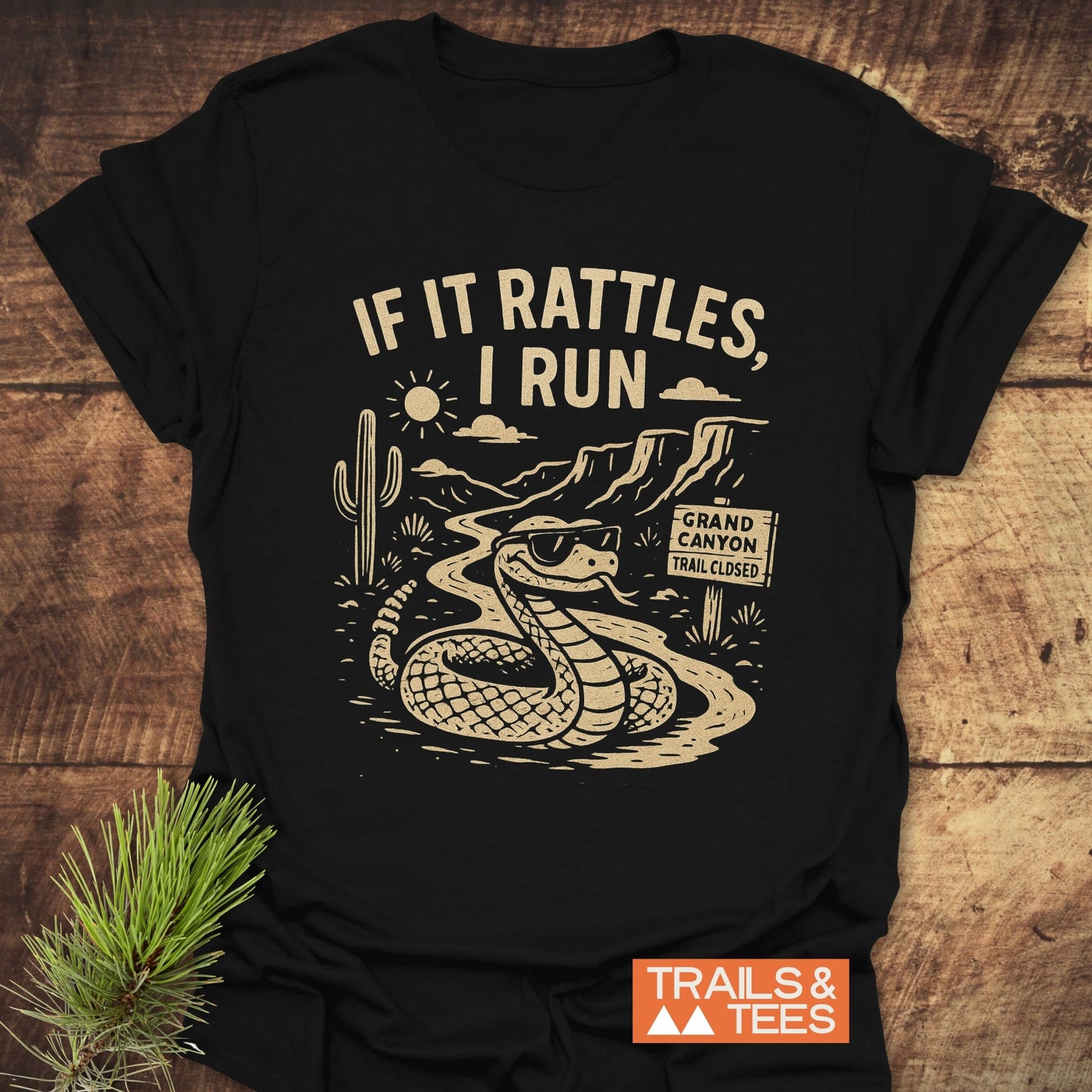 If It Rattles Funny T-Shirt features a snake and cactus design, crafted from soft cotton for outdoor adventures, offering durable prints and a reliable fit.