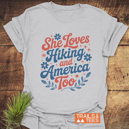 She Loves Hiking And America Too T-Shirt, featuring durable text design on soft, lightweight cotton, offering lasting comfort and a reliable fit for outdoor adventures.