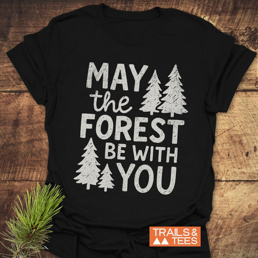 May The Forest Be With You T-Shirt features bold white text and tree silhouettes on black, emphasizing outdoor adventure and sustainability.