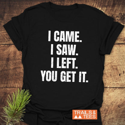 Black I Came. I Saw. I Left. T-shirt on wood, featuring distressed white text. Includes TRAILS & TEES logo, showcasing lightweight, adventure-ready design.