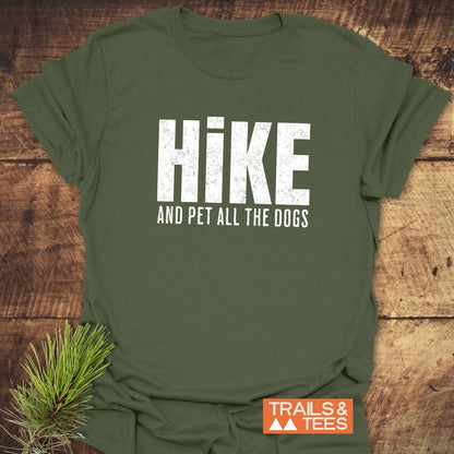 Forest-green Hike And Pet Dogs T-shirt, displayed flat with pine sprig, featuring distressed white lettering. Soft, ring-spun cotton for outdoor enthusiasts.
