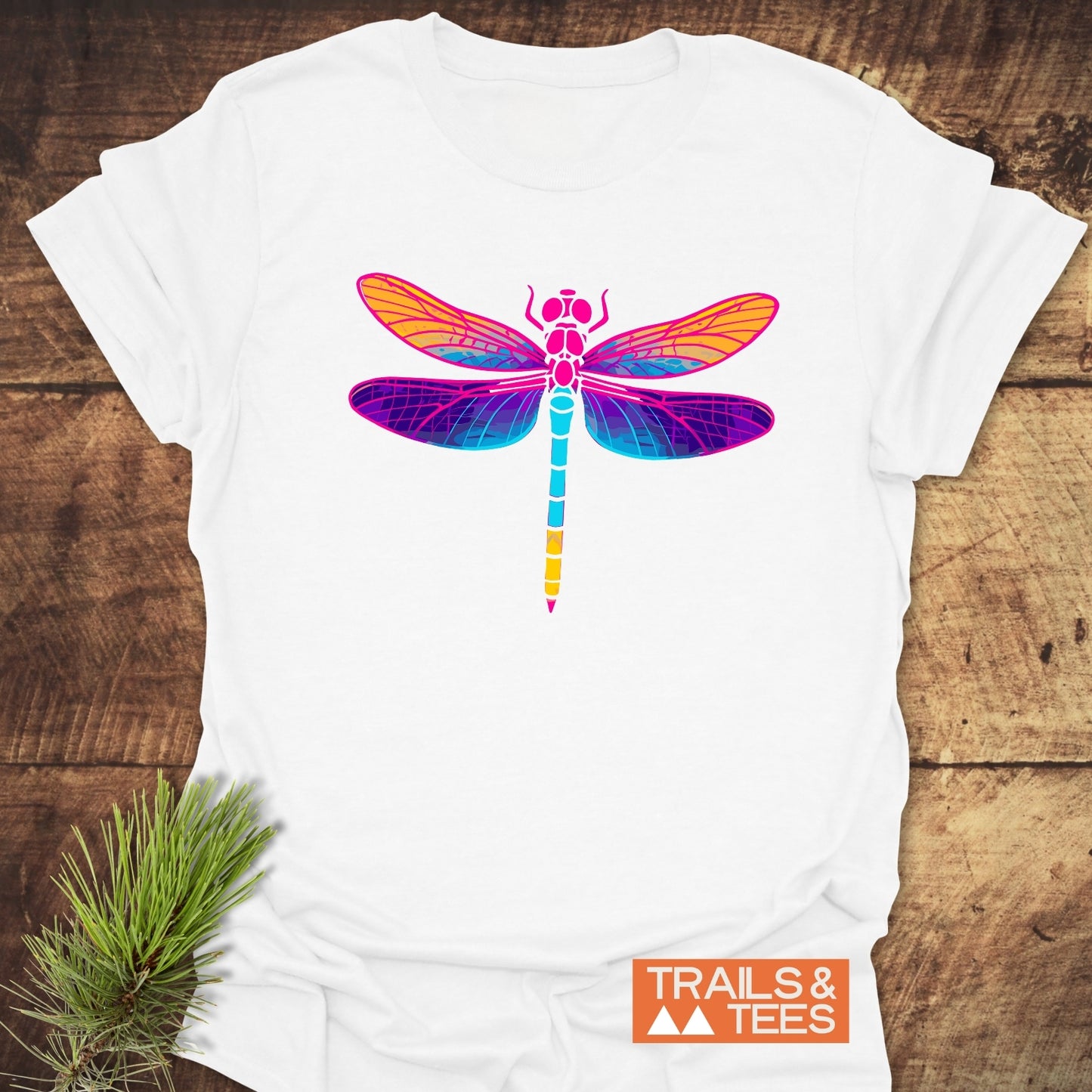 Psychedelic Dragonfly T-Shirt features a vibrant dragonfly graphic on soft, lightweight cotton, ideal for outdoor adventures. Includes TRAILS & TEES logo.