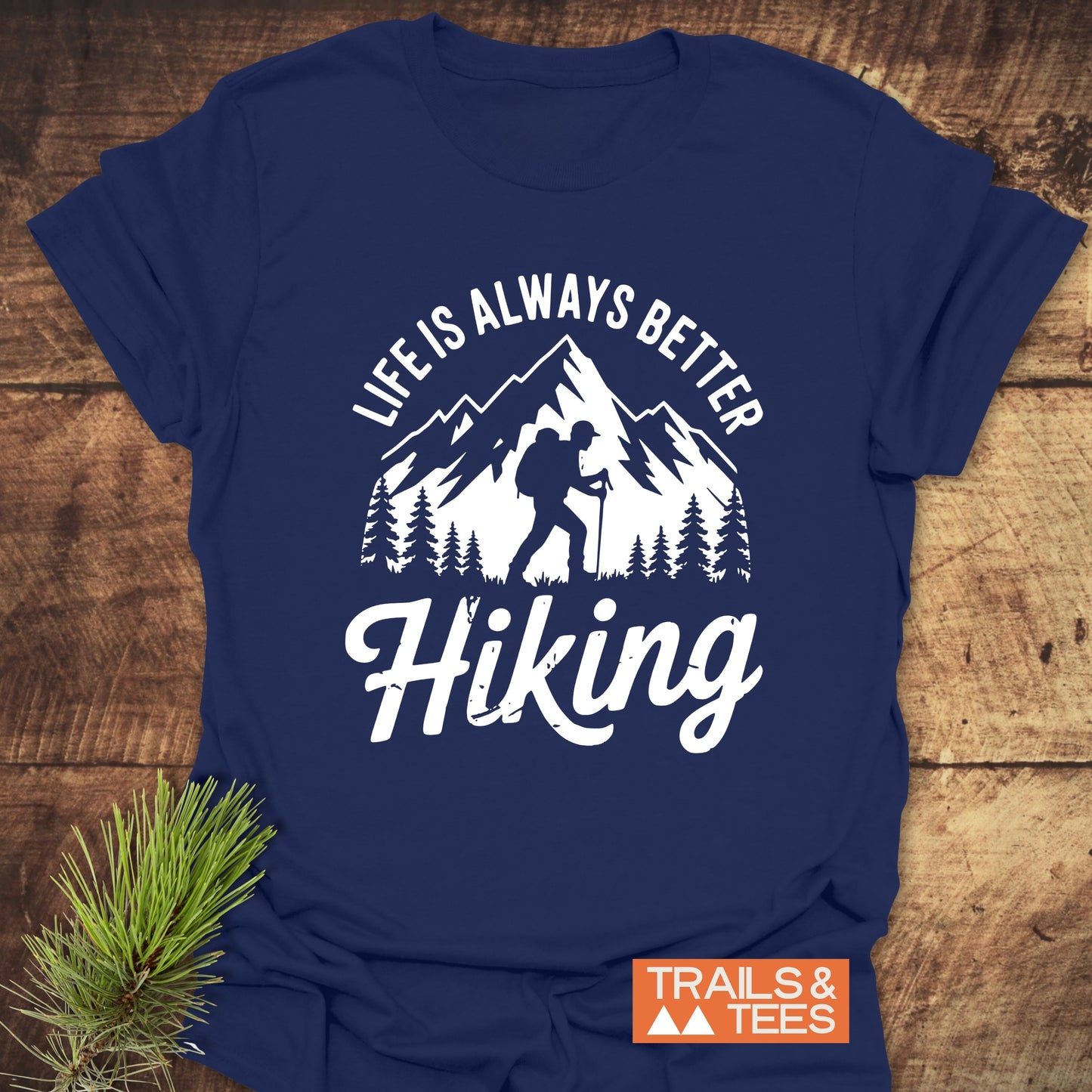 Life Is Always Better Hiking T-Shirt, navy-blue with a mountain scene and hiker graphic, emphasizes outdoor adventure; crafted for comfort and durability.