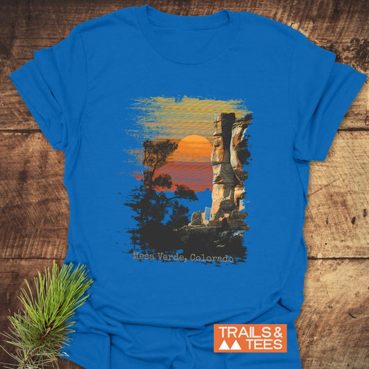 Mesa Verde, Colorado T-Shirt with a brush-stroke scene of a sunset, tree, and cliff. Features durable print and soft ring-spun cotton, branded by TRAILS & TEES.