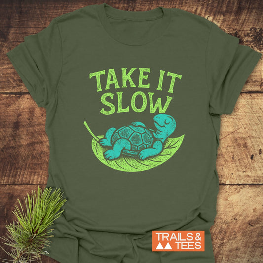 Take It Slow T-Shirt featuring a turquoise turtle on a leaf with TAKE IT SLOW text, highlighting comfort and durability for outdoor enthusiasts.