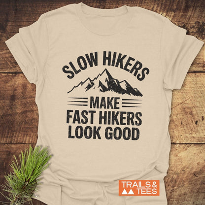 Slow Hikers T-Shirt featuring a mountain graphic and humorous text, styled with a pine sprig, showcasing rustic outdoor appeal and durable, comfortable design.