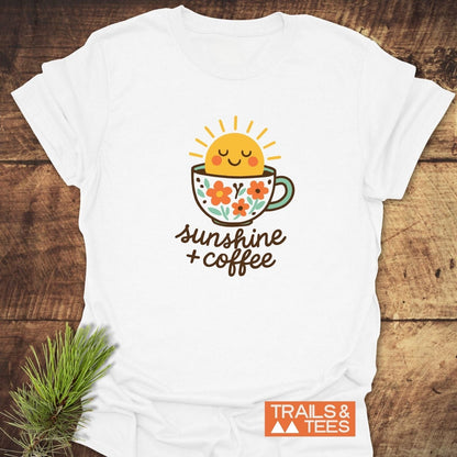 Sunshine And Coffee T-Shirt featuring a smiling sun in a coffee cup graphic, hand-lettered phrase, crafted for comfort with durable prints and outdoor style.