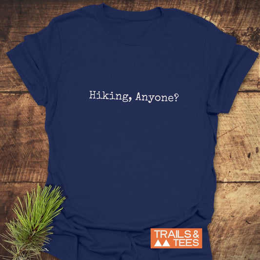 Navy-blue Hiking, Anyone? T-shirt on wood background, featuring typewriter-style font, durable print, and eco-conscious design by TRAILS & TEES.
