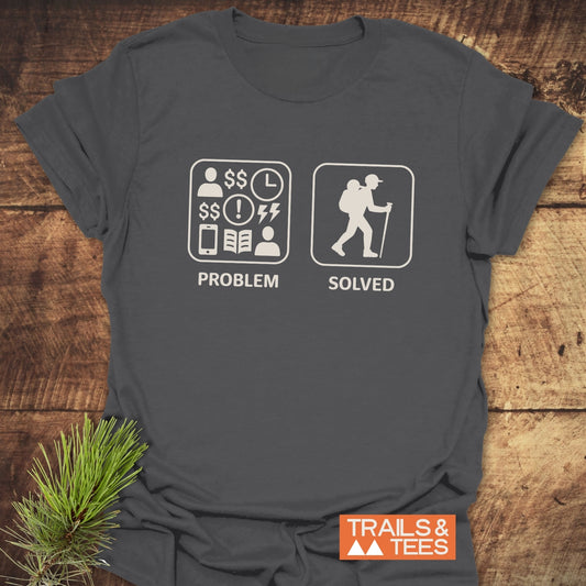 Dark-gray T-shirt featuring Problem Solved graphic with stress icons and hiker, showcasing Trails & Tees logo, styled with a pine sprig.