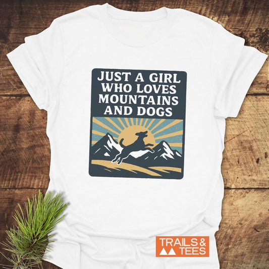 Just A Girl Who Loves Dogs T-Shirt with a mountain and dog graphic, made of soft ring-spun cotton, pre-shrunk, durable print, featuring Trails & Tees logo.
