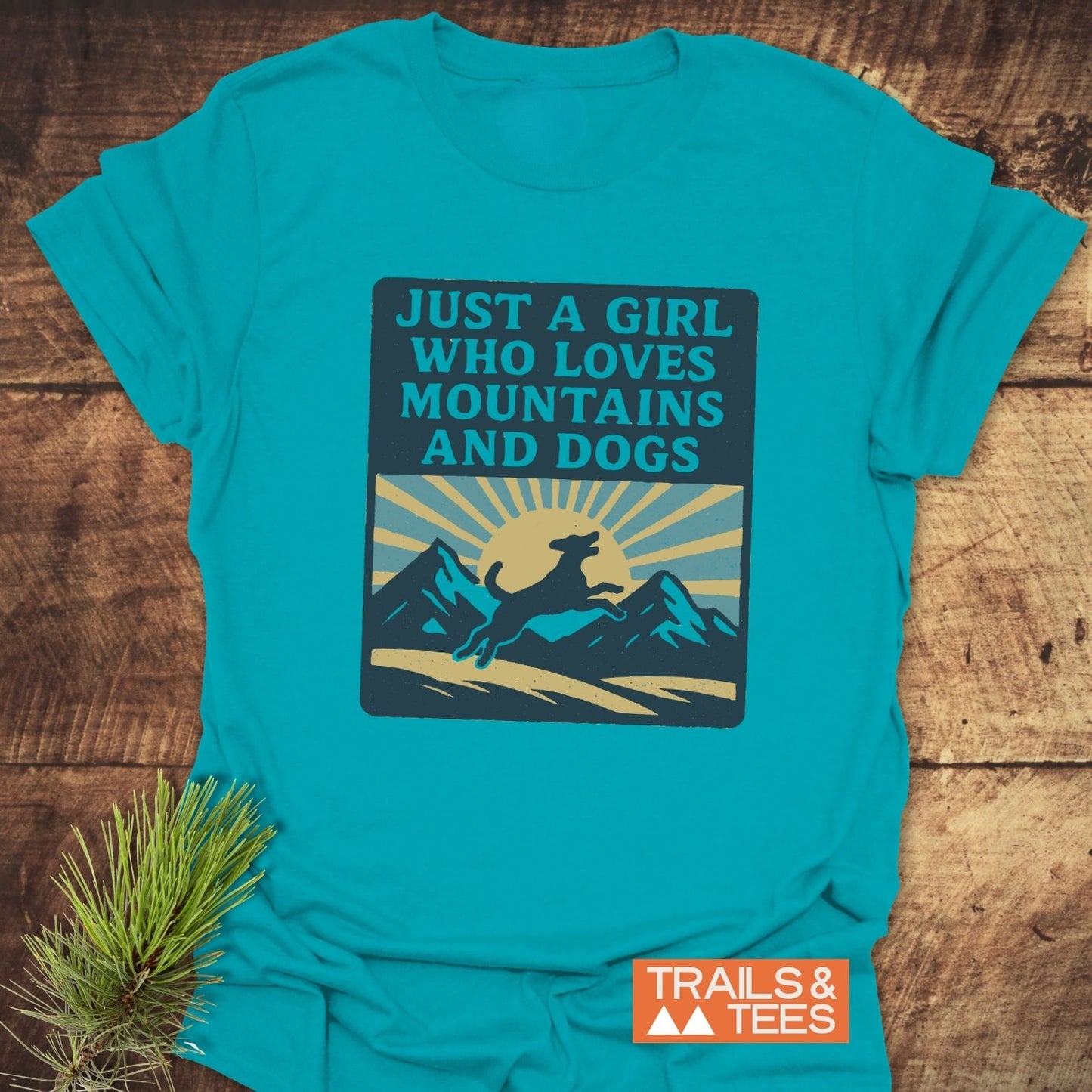 Just A Girl Who Loves Dogs T-Shirt with retro mountain and dog graphic, showcasing comfort-focused, adventure-ready design from Trails & Tees, accented by pine sprig.