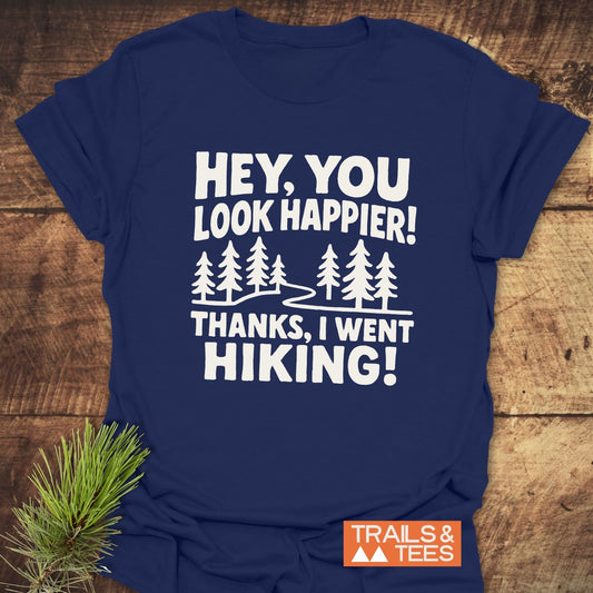 Hey, You Look Happier T-Shirt with evergreen trees and hiking text on navy-blue, crafted from soft cotton, featuring durable prints and eco-friendly production.